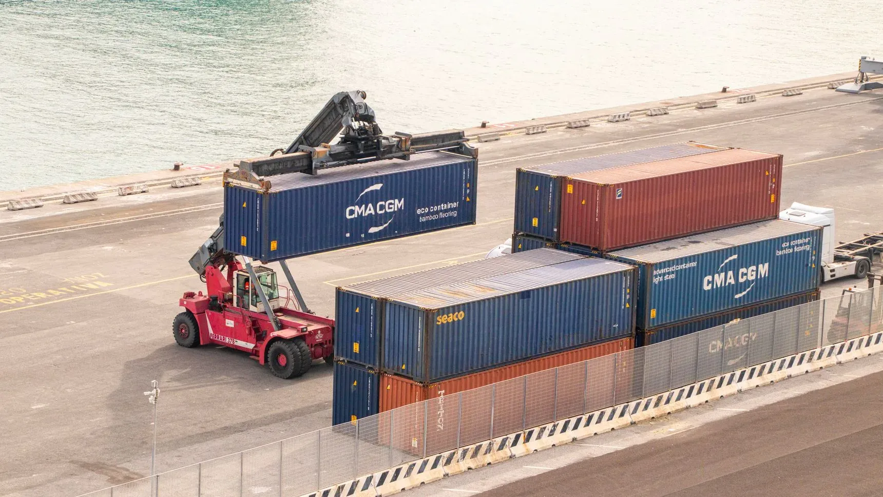 A forklift moving shipping containers in a port in daylight